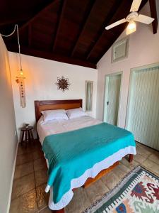 a bedroom with a bed and a ceiling fan at Suites e Casa_Pauba in São Sebastião