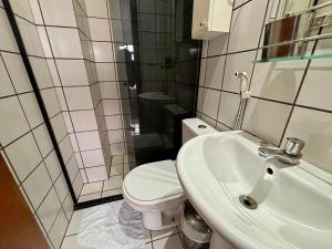 een witte badkamer met een toilet en een wastafel bij Estudio Ao Lado do Parque - 15 mim do Aeroporto. in Brasilia +27 foto's