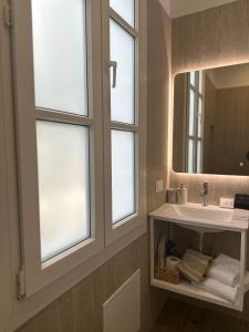 een badkamer met een wastafel, een spiegel en ramen bij Maissance in Preveza +30 foto's
