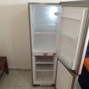 een lege koelkast met de deur open in een keuken bij Chez Bernard in Libreville