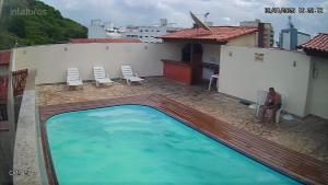 a man standing next to a swimming pool on a building at Jardim Caribenho in Arraial do Cabo