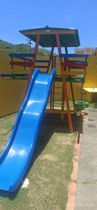 a blue slide in front of a picnic table at Jardim Caribenho in Arraial do Cabo