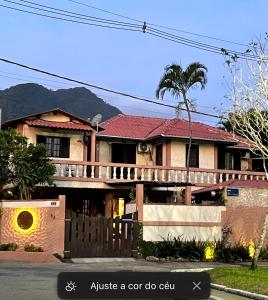 a house with a porch and a deck at Suites e Casa_Pauba in São Sebastião