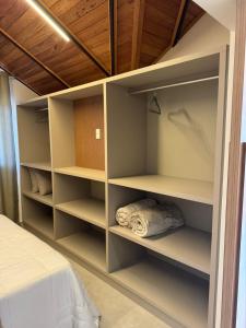 une chambre avec un placard avec étagères et un lit dans l'établissement Loft Nápoles, à Santa Teresa