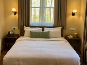 een groot wit bed in een kamer met een raam bij Maissance in Preveza