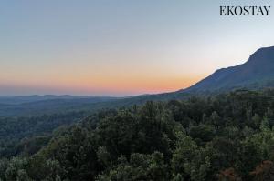 an image of a sunset in the mountains at EKOSTAY - Forest Cube Villa in Attigundi