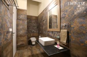 a bathroom with a sink and a toilet in it at EKOSTAY - Forest Cube Villa in Attigundi