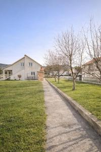 un sentiero in un cortile con una casa e degli alberi di Apartman Mila a Golubić Altre 13 foto