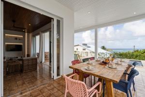 a dining room with a table and chairs and the ocean at Villa Calaïa in Tartane