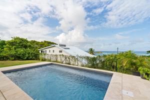 a swimming pool in front of a house with the ocean at Villa Calaïa in Tartane