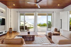 a living room with a couch and a ceiling fan at Villa Calaïa in Tartane