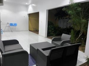 een terras met zwarte stoelen en een tafel en een tafel met stoelen bij Teranga in Mbour