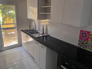 een witte keuken met een wastafel en een raam bij Teranga in Mbour +5 foto's