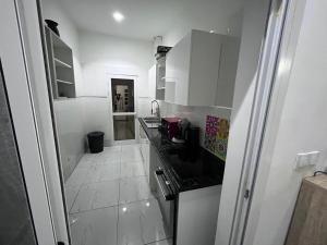 een keuken met witte kasten en een zwart aanrechtblad bij Teranga in Mbour