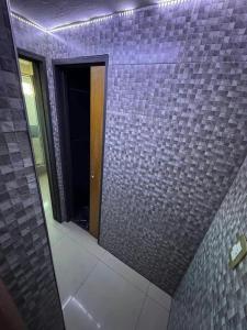 un bagno con una parete piastrellata viola con uno specchio di Hostel Wilde a Wilde