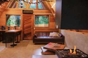 a living room with a couch and a fireplace at CHALÉS SUIÇOS - Românticos na Natureza para adultos - Pernoite das 17h às 11h in Itapecerica da Serra