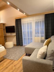 een woonkamer met een bank en een televisie bij Appartement Schmid in Oetz