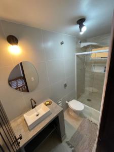 a bathroom with a toilet and a sink and a shower at Suites e Casa_Pauba in São Sebastião