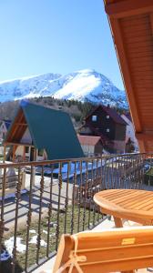 a balcony with a table and a snow covered mountain at Durmitor Sunstone in Žabljak