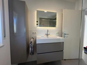 un bagno con un lavandino bianco e uno specchio di Raum 7 a Bad Schwalbach