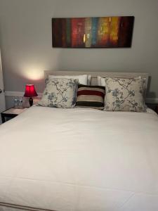 a bed with white sheets and pillows in a bedroom at Pamoyo Place in Albany
