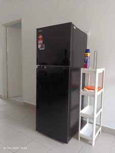 a black refrigerator with a ladder next to it at Halia Homestay in Batu Pahat