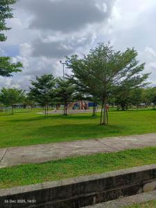 a park with a tree in the middle of a field at Halia Homestay in Batu Pahat