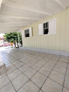 een lege patio met twee ramen en een wit dak bij Chalé com garagem fechada in Pântano Grande