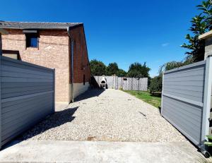 une allée avec deux portes en face d'une maison dans l'établissement Gîte de Montapeine 8, à Breteau