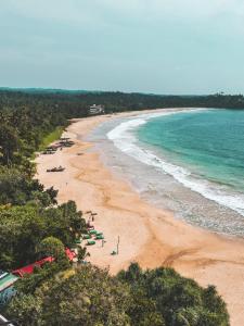 een strand met parasols en de oceaan bij Secret Beach - Talalla in Talalla South