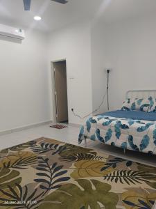 a bedroom with a bed and a rug at Halia Homestay in Batu Pahat