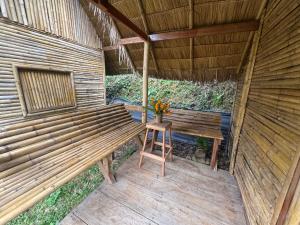 a bench in a room with a table and flowers at Petros Bungalows in Nongkhiaw +42 photos