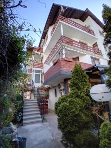 a house with stairs up to the front of it at Guesthouse Oasis in Kiten