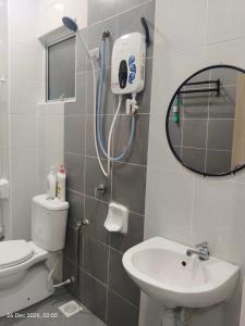 a bathroom with a shower and a toilet and a sink at Halia Homestay in Batu Pahat +10 photos