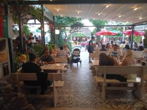 a group of people sitting at tables in a restaurant at Guesthouse Oasis in Kiten