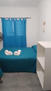 ein blaues Bett in einem Zimmer mit einem blauen Vorhang in der Unterkunft Departamento CR in Alta Gracia + 10 Fotos