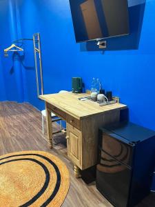 einen Holzschreibtisch in einem Zimmer mit blauer Wand in der Unterkunft CenterPoint Thong Sala in Thongsala