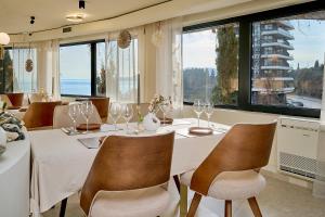 a dining room with a table and chairs and windows at Skyline Sunset in Becici