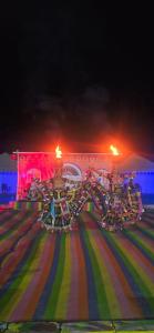 ein Fahrgeschäft auf dem Jahrmarkt mit einem Pferd am Boden bei Nacht in der Unterkunft White Thar Camp in Dhordo