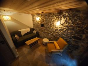 un salon avec un canapé et un mur en pierre dans l'établissement Un Coin De Gîtes, à Sciez