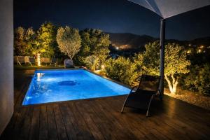 une piscine avec une chaise sur une terrasse la nuit dans l'établissement Villa Porto-vecchio 4 chambres avec piscine, à Porto-Vecchio 23 autres photos