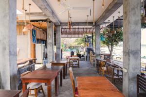 een leeg restaurant met houten tafels en stoelen bij Amed Sari Beach Guesthouse in Amed
