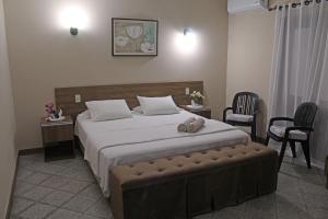 a bedroom with a large bed and two chairs at Das Heim Hotel in Asunción