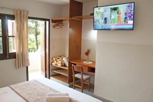 a room with a bed and a television on a wall at Das Heim Hotel in Asunción