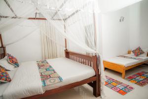 twee bedden in een kamer met klamboes bij Villa Prime Time Unawatuna in Unawatuna