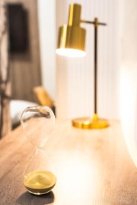 een zandloper die op een tafel naast een lamp staat bij Royal Luxury Suit in Iaşi +6 foto's
