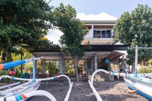een groep boten geparkeerd voor een gebouw bij Amed Sari Beach Guesthouse in Amed