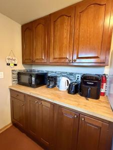 une cuisine avec des armoires en bois et un comptoir dans l'établissement Cozy Rustic Retreat on a Horse Ranch with Stunning Pikes Peak Views and Serenity Minutes from Downtown Woodland Park, à Woodland Park 23 autres photos