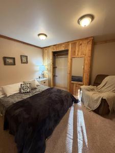 une chambre avec un grand lit et un miroir dans l'établissement Cozy Rustic Retreat on a Horse Ranch with Stunning Pikes Peak Views and Serenity Minutes from Downtown Woodland Park, à Woodland Park