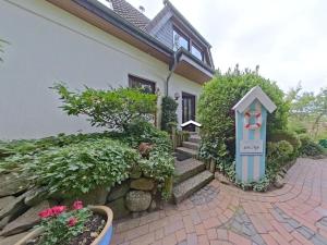 a house with a garden with a sign in front of it at Ferienwohnung Smutje in Kiel +13 photos